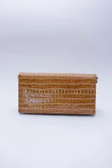 Cartera negra con textura símil cocodrilo y cadena metálica plateada.