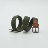 Cinturón verde oliva trenzado con hebilla metálica plateada y detalles en cuero marrón.