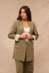 Blazer verde oliva de corte largo y holgado, con solapas clásicas, bolsillos frontales con solapa y mangas largas con vuelta estampada a rayas.