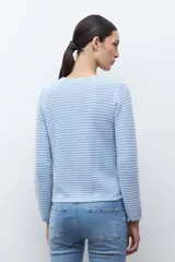 Chaqueta de punto color celeste, con cuello redondo, manga larga y cierre frontal con botones metálicos plateados.