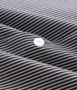 Camisa de corte regular para hombre, en color celeste con finas rayas verticales blancas. Cuenta con cuello camisero tradicional, mangas largas con puños abotonados y cierre frontal con botones.