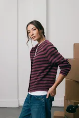 Saco tejido de punto a rayas horizontales en tonos violeta y marrón, con cuello redondo, manga larga y cierre frontal con botones.