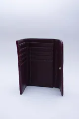 Billetera negra de cuero con textura tipo cocodrilo, con múltiples ranuras para tarjetas y billetes.