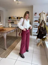 Pantalón de corte recto confeccionado en pana color bordó, con cintura alta y cierre frontal.