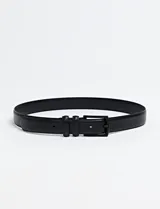 Cinto Harrington Urban color negro, confeccionado en cuero sintético, con hebilla metálica oscura y dos trabillas.