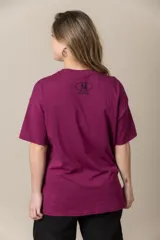 Remera gris con estampa de la letra M en negro y cadena plateada en el cuello.