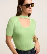 Blusa de tricot color verde claro, de manga corta y escote redondo con abertura frontal.