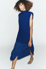 Vestido midi de color azul eléctrico con cuello subido y diseño sin mangas. Presenta un cuerpo liso y una falda con caída fluida y detalle de tul en el bajo.