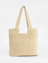 Cartera tipo canasto playero de color beige, confeccionada en papiro con diseño tejido a crochet, asas de hombro y cierre en el compartimento principal.