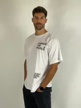 Remera blanca de corte holgado con estampa tipográfica en negro en el pecho y en la parte inferior lateral.
