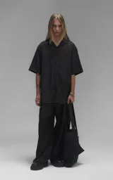 Camisa de manga corta con calce oversize, confeccionada en tejido de lyocell, con cuello clásico y cierre frontal de botones.