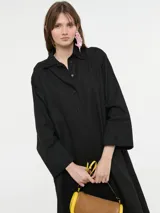 Vestido camisero oversized color beige, confeccionado en 83% ramié y 17% algodón, con mangas amplias, puños altos y cartera con botones delanteros.