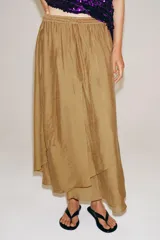 Falda midi de tiro medio color tostado, con cintura elástica ajustable con cordón y diseño asimétrico de volantes superpuestos.
