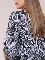 Blusa de manga tres cuartos abullonada, con escote bote y estampado floral en tonos negros y blancos.