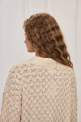 Cardigan de punto calado color tostado, con escote en V y cierre frontal de botones.