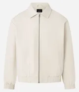 Campera masculina de corte boxy en color beige, con cuello inglés, cierre frontal de cremallera, mangas largas con puños elásticos y ruedo con elástico. Presenta bolsillos laterales y detalles de recortes en el diseño.