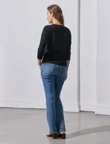 Cardigan blanco de tejido fino con abertura central y botones.