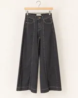 Jeans wide leg color negro gastado, con tiro alto, cortes frontales pespunteados y botamanga ancha.