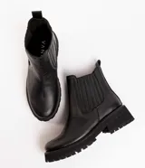 Bota Chelsea de cuero negro con elástico lateral, suela track y tirador trasero.