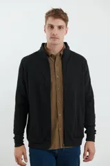 Cardigan de tejido de punto color verde militar, con cierre frontal de metal y cuello redondo. Presenta detalle de tejido plano en la cartera del cierre y en los bolsillos laterales.