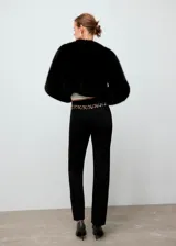 Chaqueta corta de efecto pelo sintético en color negro, con cuello redondo, diseño recto y manga larga.