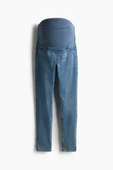 Jean skinny de denim elástico color azul, de corte ajustado, con bolsillos simulados al frente, bolsillos posteriores y faja de punto ancha para el soporte de la barriga de maternidad.