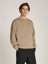 Remera de manga larga color beige, de tejido slub con textura rústica. Tiene cuello redondo y puños con elástico.