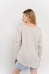 Remera manga larga color rosa con bolsillo en el pecho y corte irregular en el ruedo.