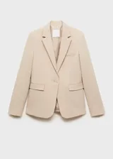 Chaqueta tipo blazer de corte entallado en color beige, con cuello de solapas con muesca, hombros estructurados, cierre frontal de un botón y bolsillos de ribete delanteros.