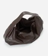 Cartera modelo hobo de gran tamaño, confeccionada en poliuretano con acabado brillante y textura suave. Presenta un diseño de media luna con asa ancha integrada para llevar al hombro y cierre superior.