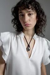 Blusa color crudo de tela satinada con escote en V y mangas cortas con volados.