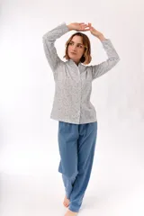 Pijama de dos piezas con estampado floral en tonos rosados y celestes sobre fondo blanco. La camisa es de manga larga con cuello mao y cierre frontal con botones. El pantalón es largo y de corte recto.