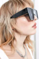 Lentes de sol rectangulares oversized de estilo tecno, con marco negro y cristales oscuros. Ofrecen filtro de protección UV 400 que bloquea rayos UVA y UVB.