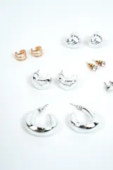 Set de aros variados que incluye pares de argollas plateadas de distintos tamaños, aros abridores con circón y perlas, y aros dorados de diseño geométrico.