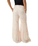 Pantalón palazzo color crema con estampado floral en tonos rosados y detalles de encaje en los ruedos.