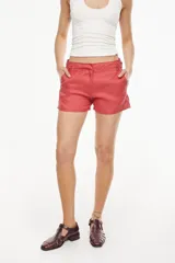 Short de lino color coral, con bolsillos laterales y cierre frontal oculto.