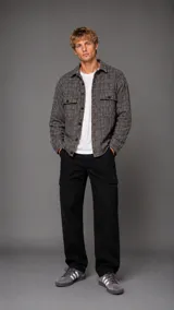 Camisa tipo overshirt de manga larga con diseño a cuadros en tonos grises y marrones. Presenta cuello clásico, cierre frontal con botones y dos bolsillos frontales con solapa en el pecho.