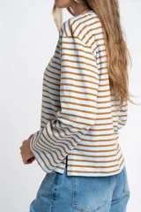 Remera de manga larga con cuello redondo, confeccionada en algodón con elastano. Presenta un diseño de rayas horizontales en color azul marino sobre fondo blanco.