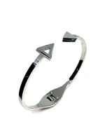 Pulsera rígida de acero plateado con forma de brazalete abierto, con cierre de resorte y terminaciones en forma de triángulos.