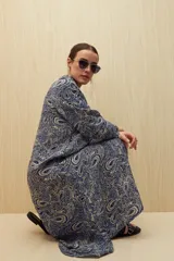 Vestido midi con estampado paisley en tonos azules y beige, con cuello camisero y abotonadura frontal.