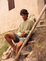 Sweater de algodón negro con diseño de tejido calado, cuello redondo y manga larga.