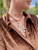 Collar con colgante de perlas irregulares y detalles en dorado, con cordón doble color marrón.