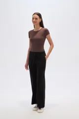 Pantalon de corte holgado y tiro alto, confeccionado en tejido de poliester con textura acanalada. Presenta cintura elástica con cordón de ajuste y diseño de pierna ancha.