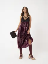 Vestido largo negro con lentejuelas y detalles de encaje, con tirantes finos y escote en V.