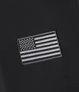 Campera tipo bomber color negro, con cierre frontal, cuello, puños y ruedo acanalados. Presenta parches bordados en el pecho con la bandera de Estados Unidos y el logo de la NASA, además de un bolsillo utilitario con cierre en la manga izquierda.