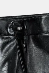 Bermuda negra de tiro alto con efecto piel, bolsillos delanteros y falsos bolsillos de vivo en la espalda. Cierre frontal con cremallera, botón interior y gancho.