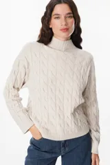 Sweater de tejido de punto con diseño de ochos, cuello alto y mangas largas con puños acanalados.