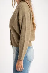 Cardigan de lana color verde oliva, con cuello en V, cierre frontal de botones y diseño de punto acanalado con corte oversize.