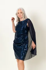 Vestido de fiesta azul con lentejuelas y capa de gasa transparente.