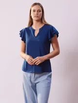 Blusa azul con cuello redondo, escote en V con aplique metálico y mangas cortas con volados en capas.